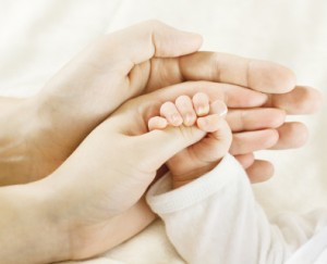 Closeup of baby  hand into parents hands. Family concept